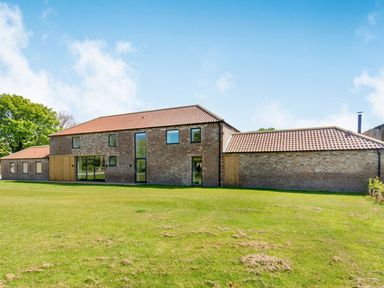 A large brick house with multiple windows and tiled roof on a grassy lawn at Partridge Place in Burton Pidsea