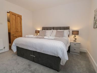 A bedroom with a double bed bedside tables and lamps at Derwent Cottage in Keswick