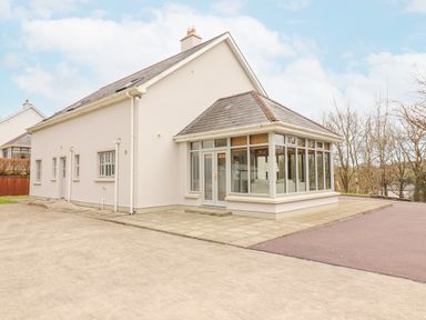 A house with large windows and a paved area in front at Hazelwood in Leap County Cork