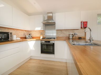 A kitchen with white cabinets wooden countertops a stainless steel oven and sink at 2 Faraway Fields in Dobwalls