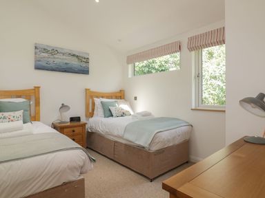 A bedroom with two single beds bedside table and lamps at 2 Faraway Fields in Dobwalls