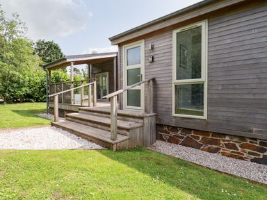 A wooden exterior of a house with stairs leading to a door and a covered porch at 6 Southern Place in Dobwalls