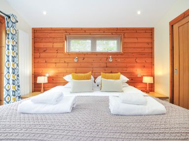 A bedroom with a double bed and wooden wall at 5 Faraway Fields in Dobwalls