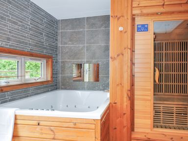 A bathroom with a bath tub and a sauna at 5 Faraway Fields in Dobwalls