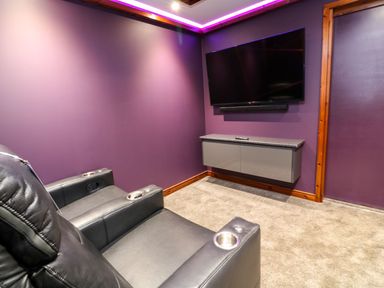 A room with two black leather chairs a wall mounted tv and a floating cabinet at 2 Southern Place in Dobwalls