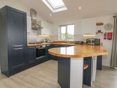 A kitchen with dark blue and white cabinets wooden countertops and a skylight at 7 Faraway Fields in Dobwalls