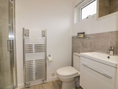 A bathroom with a toilet sink and chrome towel radiator at 7 Faraway Fields in Dobwalls