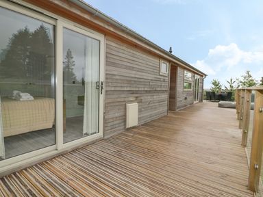 A wooden deck outside a building with sliding glass doors and outdoor furniture at 7 Faraway Fields Dobwalls