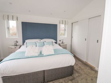 A bedroom with a double bed two bedside tables lamps and a built in wardrobe at 1 Southern Place in Dobwalls