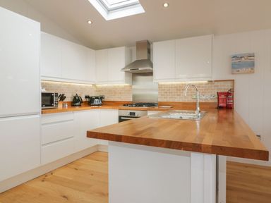 A kitchen with white cabinets wooden countertops and a skylight at 11 Faraway Fields in Dobwalls