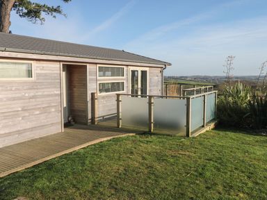 A wooden house with a small porch and frosted glass railing on a grassy lawn at 12 Faraway Fields in Dobwalls