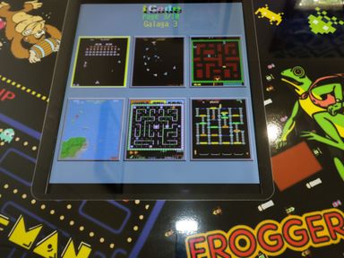 A screen showing six retro video game thumbnails on an arcade game table with frogger and pacman graphics at 18 Meadow Retreat in Dobwalls