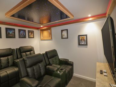 A home theater room with black recliner seats framed movie posters on walls and a ceiling with star-like lights at 18 Meadow Retreat Dobwalls