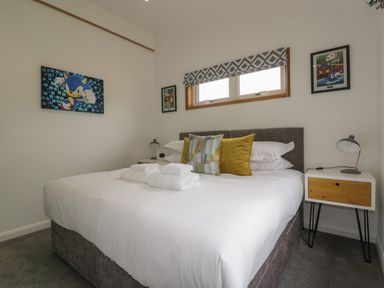 A bedroom with a bed pillows bedside tables lamps and framed pictures on the walls at 18 Meadow Retreat in Dobwalls