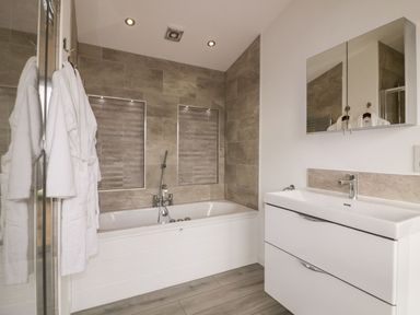A bathroom with a bathtub shower and sink with mirror cabinet at 11 Meadow Retreat in Dobwalls