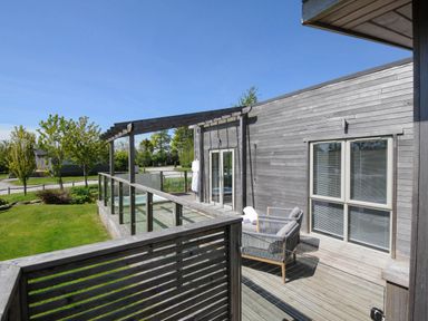 A wooden outdoor patio with glass railing and seating area at 11 Meadow Retreat in Dobwalls