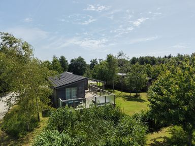 A house with a deck surrounded by trees and grass at 11 Meadow Retreat in Dobwalls