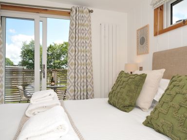 A bedroom with a bed and sliding door to a balcony at 12 Meadow Retreat in Dobwalls