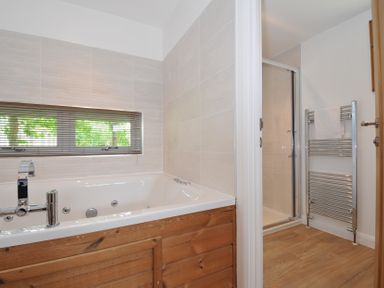 A bathroom with a bathtub and a shower at 12 Meadow Retreat in Dobwalls