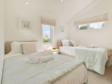 A bedroom with two single beds a nightstand between them with a lamp and windows with striped blinds at 4 Horizon View in Dobwalls