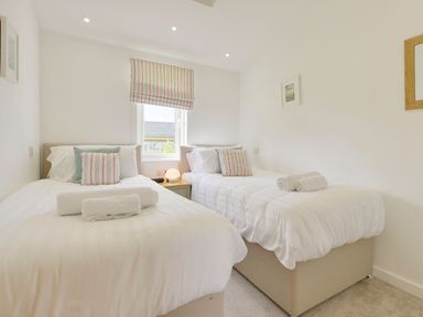 A bedroom with two single beds a window and a nightstand at 4 Horizon View in Dobwalls