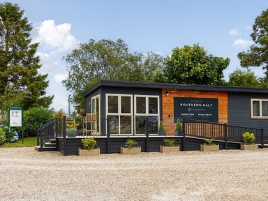 A sales suite building with signage and plants outside at Southern Halt in Dobwalls
