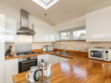 A kitchen with wooden countertops a stove kettle microwave and a French press at 14 Faraway Fields in Dobwalls