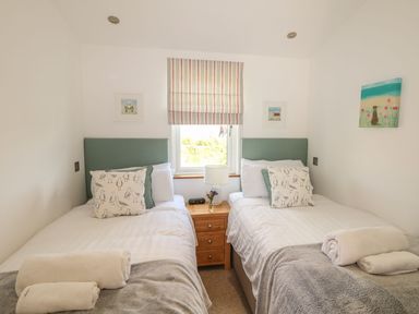 A bedroom with two single beds a window in between and a nightstand at 14 Faraway Fields in Dobwalls