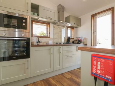 A kitchen with a built in oven and microwave a kettle stove with an extractor fan knife set toaster and cabinets at 9 Meadow Retreat in Dobwalls