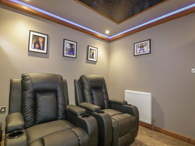 A home theater room with two black recliner chairs and framed pictures on the wall at 9 Meadow Retreat in Dobwalls