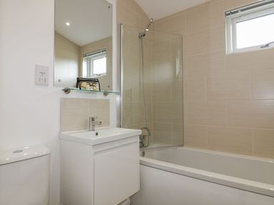 A bathroom with a bathtub shower combination sink vanity and a toilet at 7 Meadow Retreat in Dobwalls