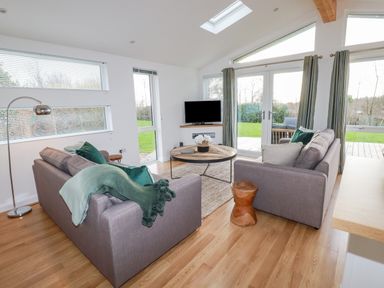 A living room with two sofas a round wooden table a floor lamp and a television at 14 Horizon View in Dobwalls