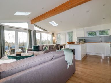 An open-plan living area with sofas, dining table, kitchen units, and large windows at 14 Horizon View in Dobwalls