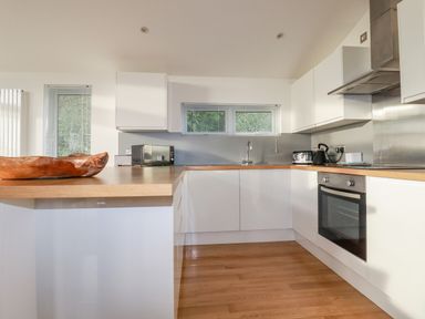 A kitchen with white cabinets wooden countertops microwave toaster kettle oven and a wooden bowl on the counter at 14 Horizon View in Dobwalls