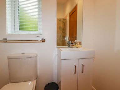 A bathroom with a toilet sink cabinet window and shower at 14 Horizon View in Dobwalls
