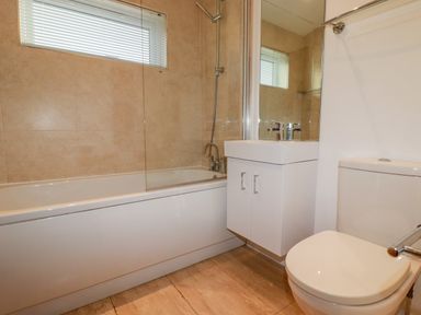 A bathroom with a bathtub shower combination a sink with cabinet and a toilet at 14 Horizon View in Dobwalls