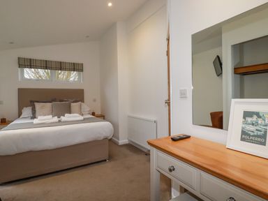 A bedroom with a double bed pillows and towels a wooden dresser with a mirror and a framed picture at 14 Horizon View in Dobwalls
