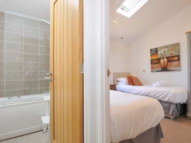A bedroom with two beds and a bathroom with a bathtub at 8 Horizon View in Dobwalls