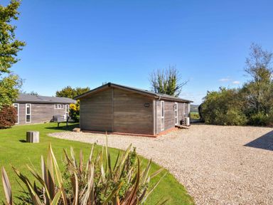 An outdoor area with wooden cabins and green grass at 10 Horizon View in Dobwalls