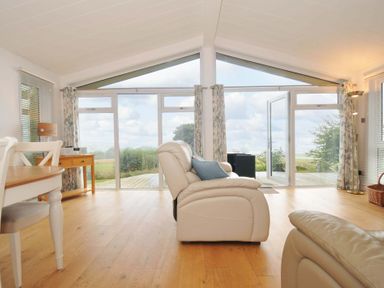 A living room with large windows and a chair at 11 Horizon View in Dobwalls