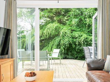A living room with a view of a deck and greenery at 15 Horizon View Dobwalls