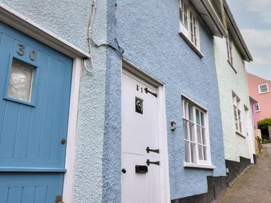 A row of painted house doors and windows along a street with house number 30 and 31 visible at 30 Sherborne Lane Lyme Regis