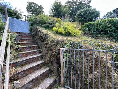A garden with stairs and a gate at Delfryn, Newport