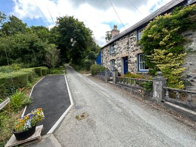 A house with a stone wall and garden at Delfryn, Newport