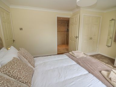 A bedroom with a bed and patterned pillows and towels on the bed at Erwlon in Rhydyfelin near Aberystwyth