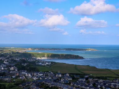 A coastal town with houses near sea cliffs and fields at Fron Olau in Nefyn