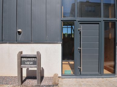 An exterior view of Breakers View with a sign at Polzeath