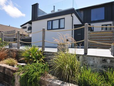 An outdoor area with a house, balcony, and plants at Breakers View in Polzeath