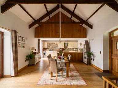 A dining room with a wooden table and chairs at Hoppers Barn in Pancrasweek near Holsworthy