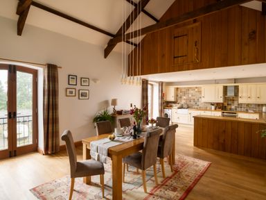 A kitchen and dining area with wooden features at Hoppers Barn Pancrasweek near Holsworthy